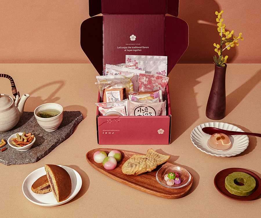 An open Sakuraco Japanese subscription box behind authentic Japanese sweets.